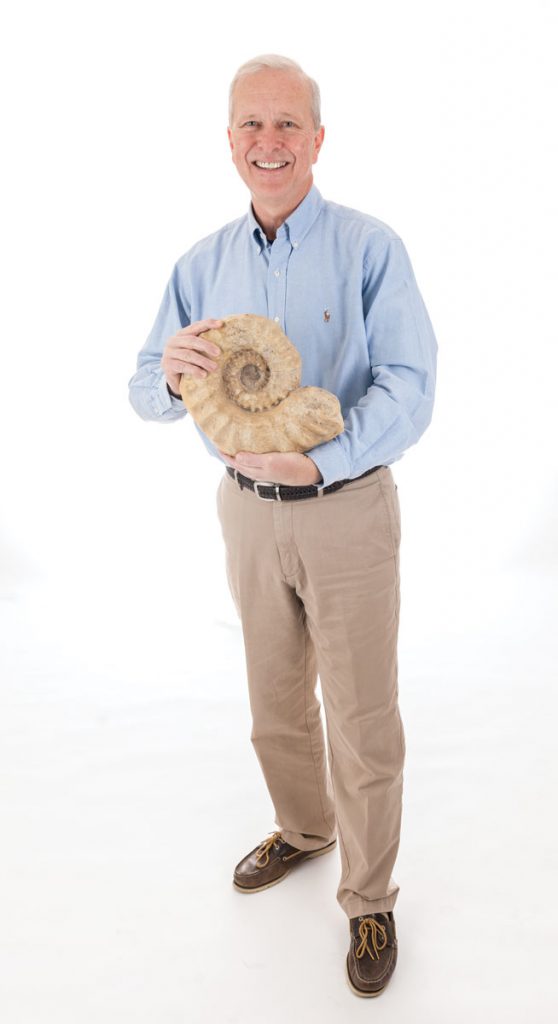 Doug Jones holds a Cretaceous-era ammonite, an ancient relative of the chambered nautilus that exists today. Photo Credits: Kristen Grace