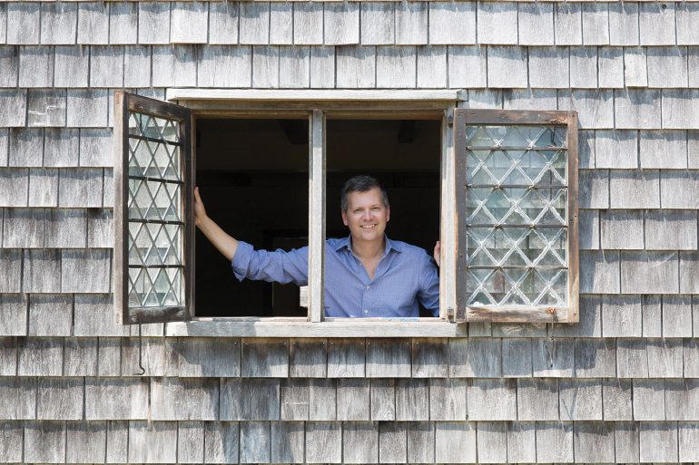 Marty Hylton peers out of a window in Nantucket’s oldest house, the Jethro Coffin house, built in 1686.