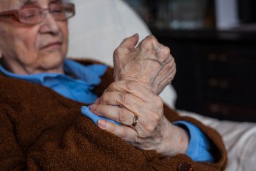 Senior citizen rubbing their wrist