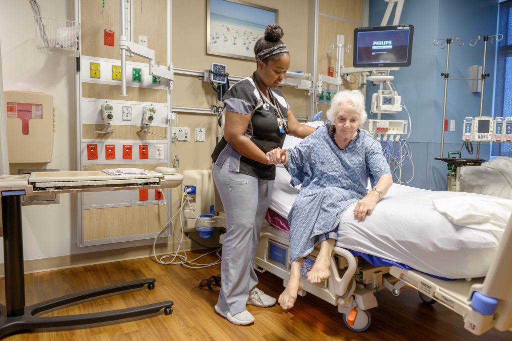 Nurse helping patient out of bed