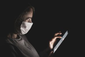 Woman wearing a protective mask while using a tablet.