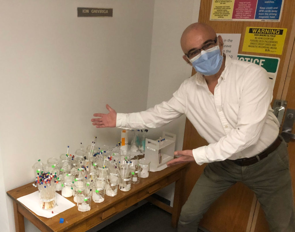 Ion Ghiviriga poses next to samples in his lab.