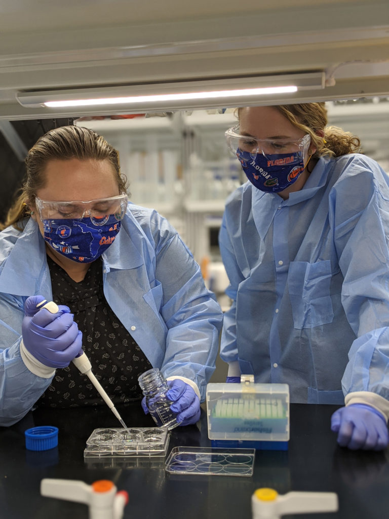 Marisa Pacheco and Julie Jameson conduct research in the Stoppel Lab wearing PPE.