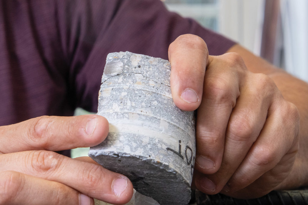 Christopher Ferraro holds a concrete and steel rebar sample from the Miami Marine Stadium