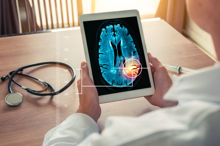 Human holding iPad with brain illustration image