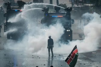 A protestor faces off with Kenyan police in Nairobi after the 2017 general election