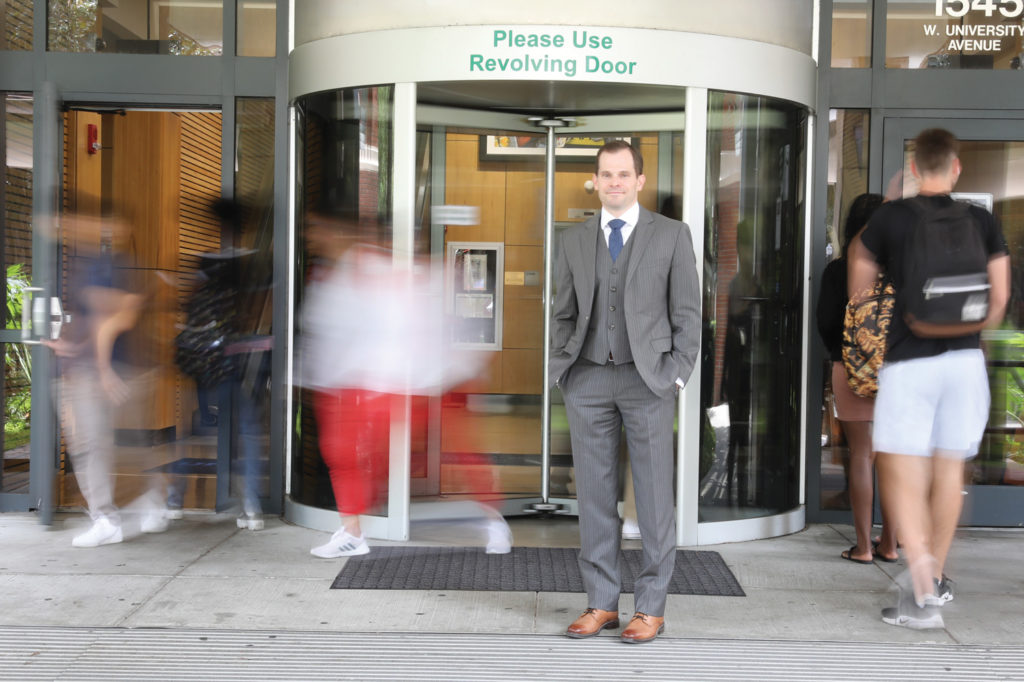 Portrait of Brian Swider in front of a revolving door. Get it?
