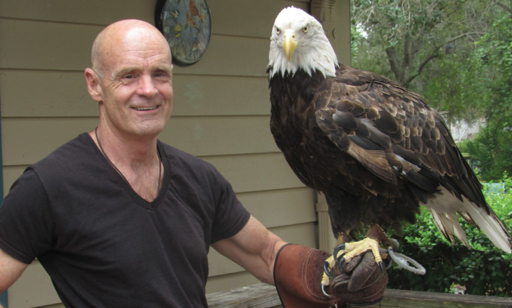 Portrait of Jack E. Davis holding a bald eagle