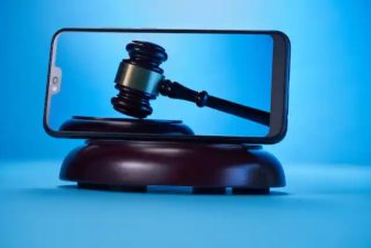 A smart phone and a gavel with a sky blue background.